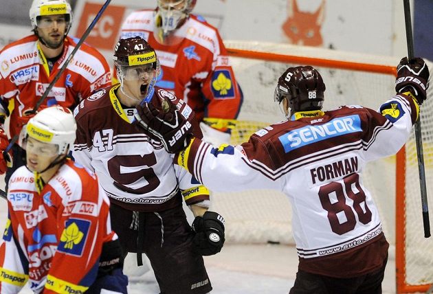 Sparťanští útočníci Jan Buchtele (č. 47) a Miroslav Forman se radují z gólu na ledě Pardubic.