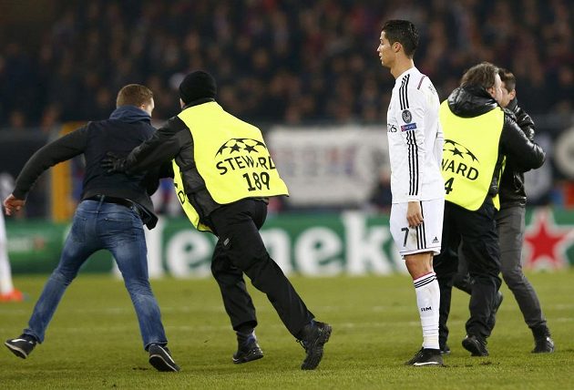 Cristiano Ronaldo z Realu přihlíží v Basileji počínání pořadatelů, kteří se snažili odchytit fanoušky na hrací ploše.
