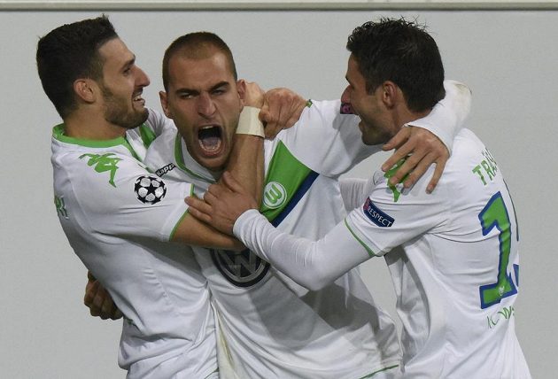 Nizozemský útočník Bas Dost (uprostřed) ve službách Wolfsburgu se raduje z trefy v utkání Ligy mistrů proti PSV Eindhoven. Vlevo Daniel Caliguri, vpravo Christian Traesch.