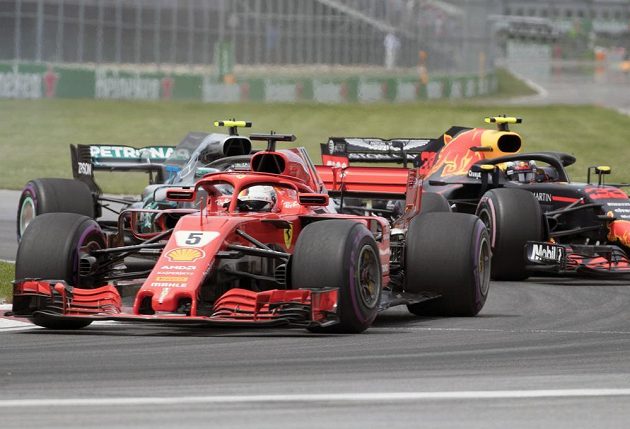 Pilot Ferrari Sebastian Vettel ujíždí dvojici Valterri Bottas (Mercedes) - Max Verstappen (Red Bull).