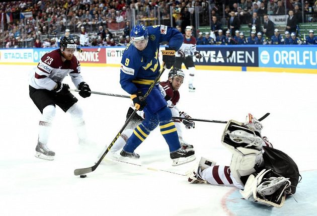 Filip Forsberg ze Švédska (uprostřed) před lotyšským gólmanem Edgarsem Masalskisem, bránit pomáhá Aleksandrs Jerofejevs (vlevo) a Kristaps Sotnieks (11).