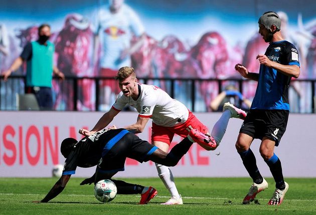 Fotbalista Jamilu Collins z Paderbornu padá, stejně jako hvězda Lipska Timo Werner během bundesligového utkání.