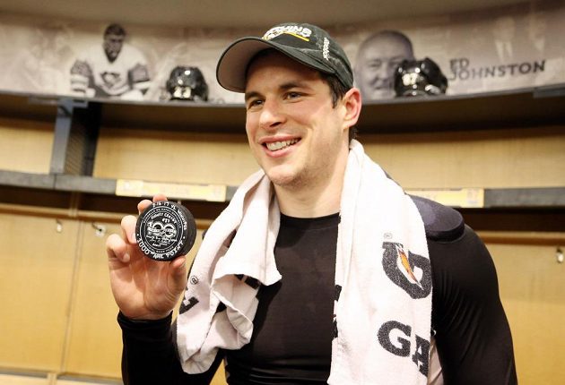 Sidney Crosby pózuje v šatně s pukem, se kterým dosáhl na metu 1000 bodů v NHL.