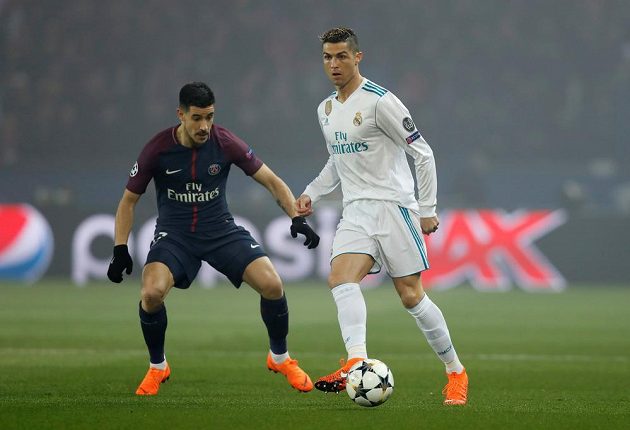 Cristiano Ronaldo z Realu Madrid odehrává míč v utkání s PSG. Akci přihlíží hráč francouzského týmu Yuri Berchiche.