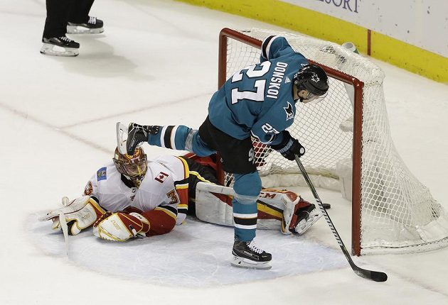 Joonas Donskoi (27) ze San Jose překonává Davida Ritticha v brance Calgary při samostném nájezdu v utkání NHL.