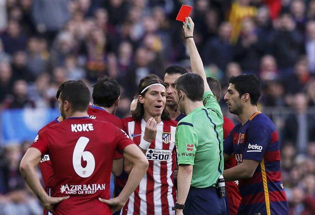 Obránce Atlétika Madrid Filipe Luís dostává po faulu na Lionela Messiho červenou kartu.