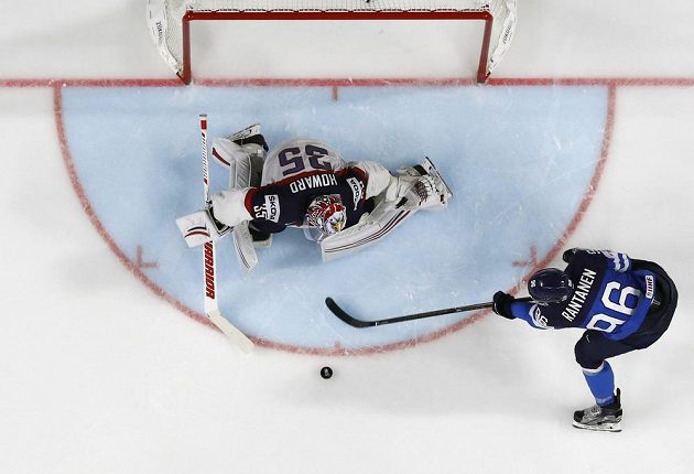 Finský hokejista Mikko Rantanen v akci před americkým gólmanem Jimmy Howardem. Fin z této akce vstřelil úvodní gól zápasu.