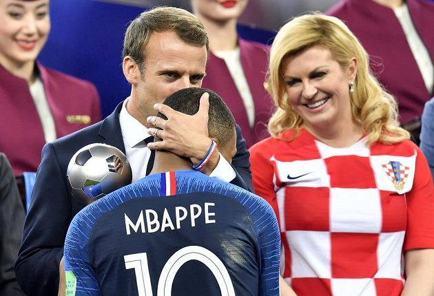 Francouzský prezident Emmanuel Macron za dohledu chorvatské prezidentky Kolindy Grabarové-Kitarovičové objímá Kyliana Mbappého.