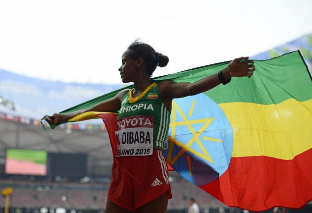 Etiopská vytrvalkyně Mare Dibabaová slaví s vlajkou zlatou medaili z maratónu na mistrovství světa v atletice v Pekingu.