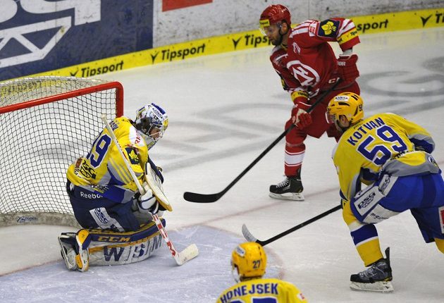 Třinecký útočník Martin Růžička (v červeném dresu) překonává zlínského brankáře Libora Kašíka ve čtvrtém semifinálovém duelu play off extraligy. Přihlížejí Antonín Honejsek a Oldřich Kotvan (zcela vpravo).