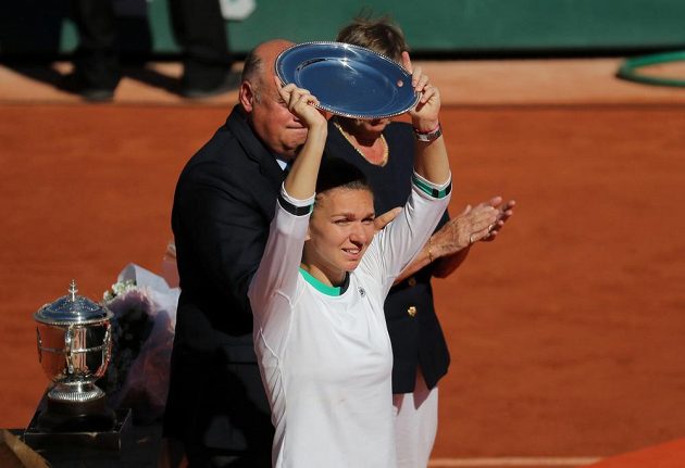 Simona Halepová zvedá nad hlavu talíř, který je určen pro poraženou finalistku Roland Garros.