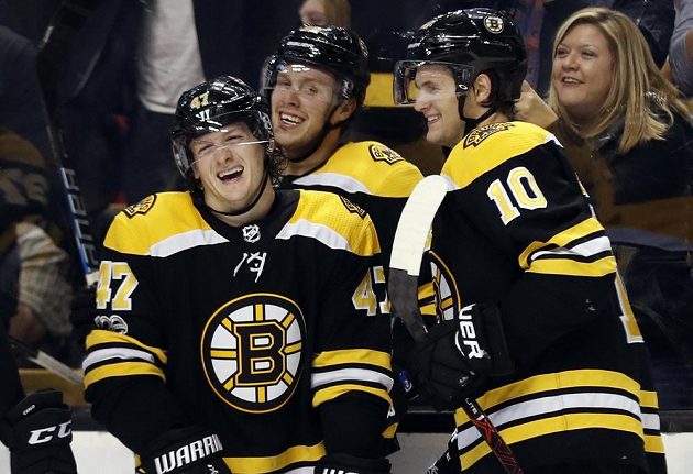 Hokejisté Bostonu Bruins Torey Krug (47), David Pastrňák a Anders Bjork (10) se radují z gólu proti Minnesotě.