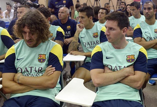 Fotbalisté Barcelony Lionel Messi a Carles Puyol (vlevo) na tiskové konferenci, kde prezident Sandro Rossel oznámil konec trenéra Vilanovy kvůli rakovině.