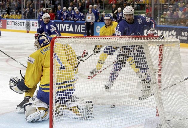 Francouzský útočník Damien Fleury (vpravo) překonává švédského gólmana Jhonase Enrotha v utkání na MS v Praze.