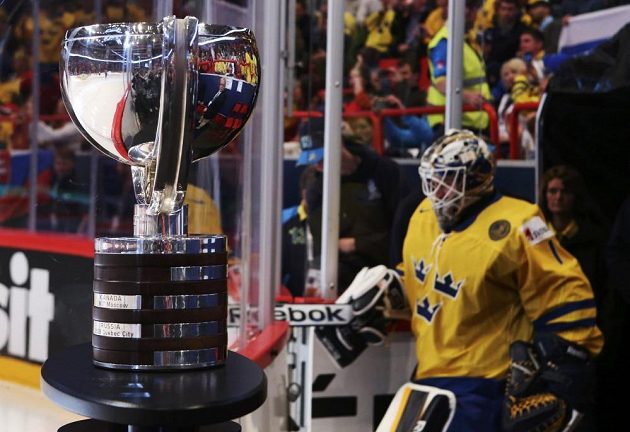 Vpředu se blyští trofej pro mistry světa. V pozadí nastupuje švédský brankář Enroth do finálového utkání.