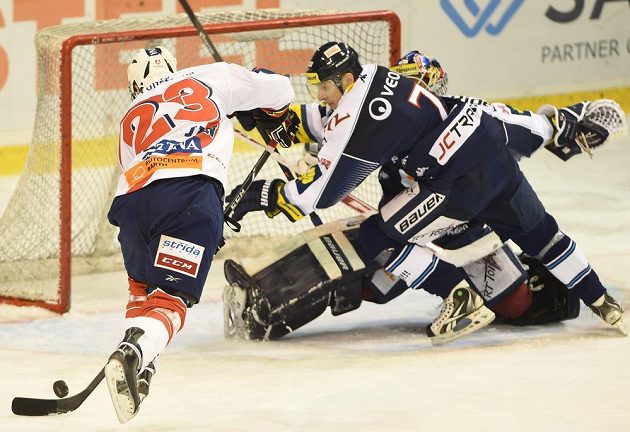 Pardubický útočník Jan Starý (vlevo) střílí gól proti Vítkovicím v druhém utkání předkola play off extraligy. Vpravo je brankář Ostravanů Daniel Dolejš, uprostřed obránce Lukáš Zíb.