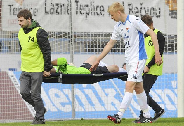 Zraněného ostravského brankáře Jiřího Pavlenku (na nosítkách) doprovází ze hřiště jeho spoluhráč Michal Frydrych.
