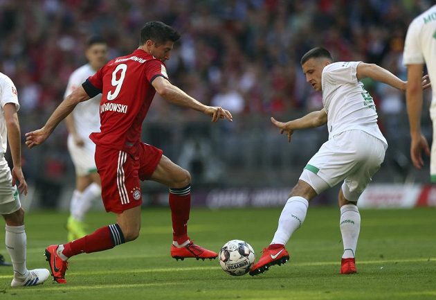 Hvězdný útočník Bayernu Robert Lewandowski bojuje o míč s obráncem Werderu Brémy Ludwigem Augustinssonem.
