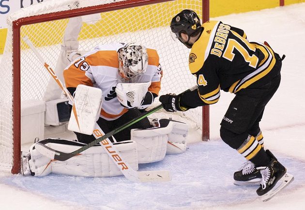 Gólman Philadelphie Flyers Carter Hart (79) zneškodnil šanci útočníka Bostonu Bruins Jakea DeBruska (74).