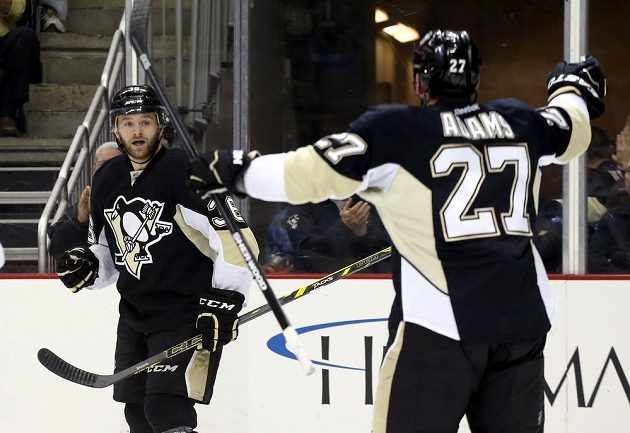 Hokejisté Pittsburghu slaví gól proti Tampě. Vlevo je útočník Bryan Rust, vpravo pak křídelník Craig Adams.