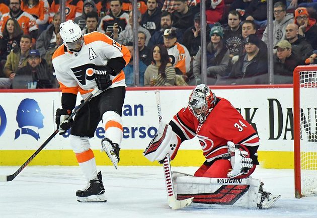 Útočník Philadelphie Wayne Simmonds se snaží nachytat v utkání NHL brankáře Caroliny Hurricanes Petra Mrázka. Tentokrát se mu to nepovedlo.