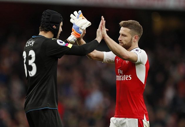 Brankář Arsenalu Petr Čech a jeho spoluhráč Shkodran Mustafi při vítězném gestu po zápase se Swansea.