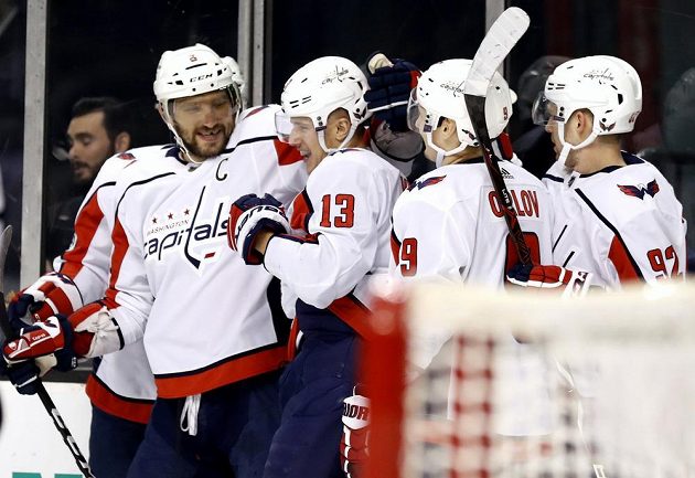 Český útočník Jakub Vrána (s číslem 13) přijímá gratulace od hokejistů Washingtonu poté, co se trefil v NHL na ledě Bostonu. Mezi gratulanty byl i hvězdný útočník Capitals Rus Alexandr Ovečkin (vlevo)