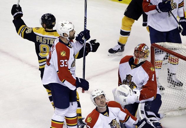 Bostonský útočník David Pastrňák (vlevo) se raduje z vyrovnávacího gólu proti Floridě. Vpravo je zklamaný brankář Panthers Roberto Luongo, uprostřed obránce Willie Mitchell.