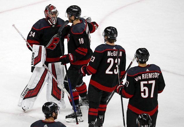 Český brankář Petr Mrázek přijímá gratulace od spoluhráčů z Caroliny po vítězném duelu s New York Rangers.