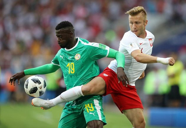 Polský reprezentant Jakub Blaszczykowski se snaží odehrát míč v utkání MS, prosadit k míči se snaží Senegalec M'Baye Niang.