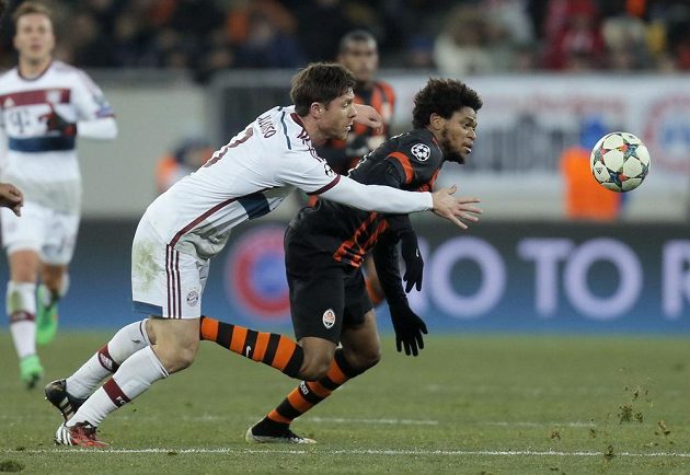 Záložník Bayernu Xabi Alonso (vlevo) se snaží zastavit Luize Adriana z Šachtaru v prvním osmifinálovém utkání Ligy mistrů.