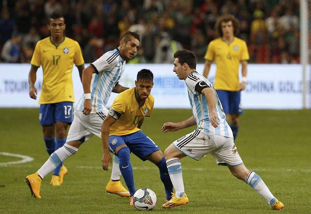 Argentinský kapitán Lionel Messi prochází okolo Brazilce Neymara, který v přátelském zápase v Pekingu rovněž navlékl kapitánskou pásku.