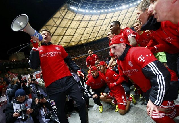 Útočník Thomas Müller byl lídrem mistrovských oslav Bayernu Mnichov - vlevo s megafonem v ruce promlouvá k vlastním fanouškům.