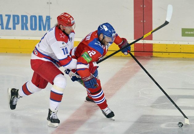 Jiří Novotný (vpravo) ze Lva Praha si kryje puk před dotírajícím Olegem Kvašou z moskevského CSKA.