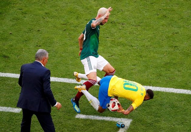 Brazilský útočník Neymar padá po kontaktu s mexickým obráncem Layúnem, který mu chce vypíchnout míč, jenž Neymar drží v náručí.