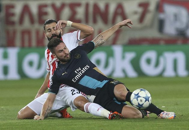 Útočníka Arsenalu Oliviera Girouda (vpravo) se snaží obrat o míč Dimitris Siovas z Olympiakosu.