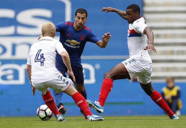 Posila v dresu Manchesteru United Henrich Mchitarjan (uprostřed) v akci při zápase ve Wiganu.