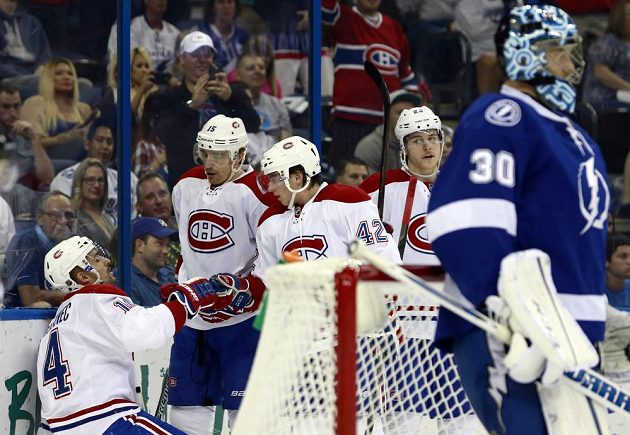 Útočník Montrealu Tomáš Plekanec (vlevo) slaví se spoluhráči gól v síti Tampy Bay. Vpravo je brankář Lightning Ben Bishop.