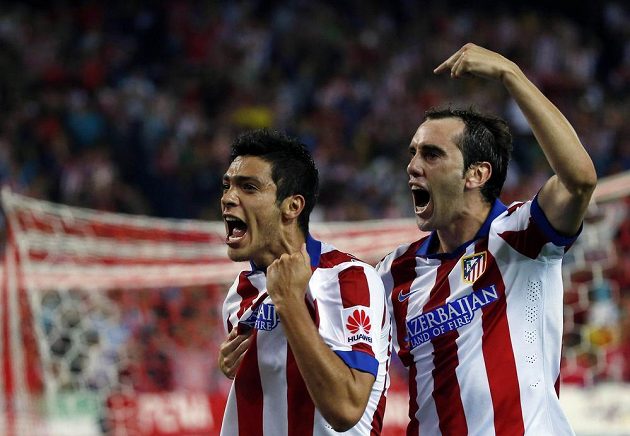 Raúl Jiménez z Atlétika Madrid (vlevo) slaví se stoperem Diegem Godínem gól v síti Sevilly.