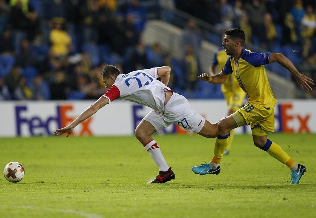 Útočník Slavie Tomáš Necid padá po souboji s Eytanem Tibim z Maccabi Tel Aviv v utkání Evropské ligy.