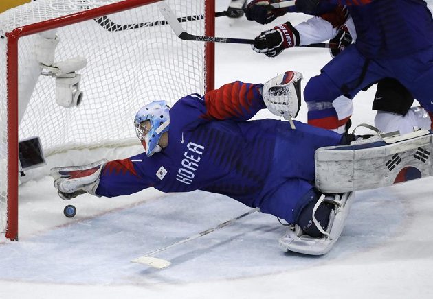 Korejský gólman Matt Dalton se vrhá po puku, který na jeho branku vyslal Švýcar Bois Felicien Du v utkání olympijského turnaje.