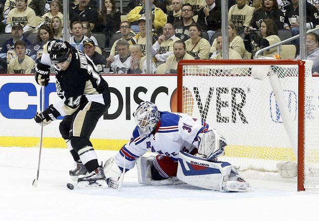 Gólman Rangers Henrik Lundqvist zasahuje proti snaze skórovat v podání pittsburghského Chrise Kunitze.