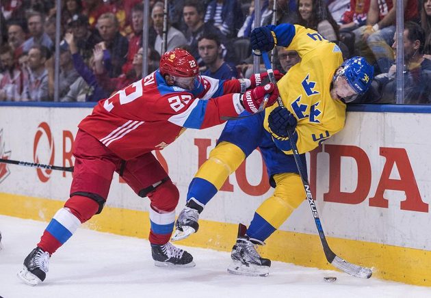 Ruský hokejista Nikita Zajcev (vlevo) atakuje Švéda Carla Söderberga v utkání Světového poháru