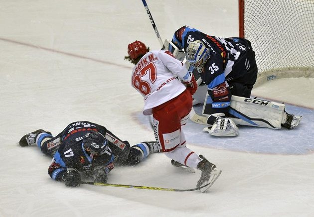 Brankář hokejových Bílých Tygrů Roman Will zasahuje, do šance se dral třinecký útočník Michal Kovařčík, liberecký obránce Lukáš Derner ho neuhlídal.