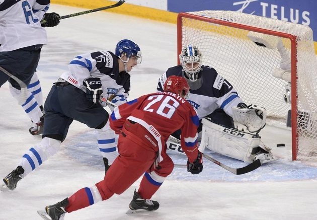 Ruský hokejista Jegor Korškov (uprostřed) se snaží překonat finského brankáře Kaapa Kahkonena během finále MS do 20 let.