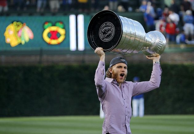 Útočník Chicaga Patrick Kane zvedá nad hlavu Stanley Cup na baseballovém stadiónu Wrigley Field.