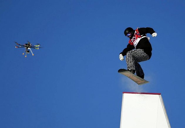 Fin Janne Korpi překonává jednu z překážek při semifinále slopestylu pod dohledem kamery na dálkově řízeném dronu.
