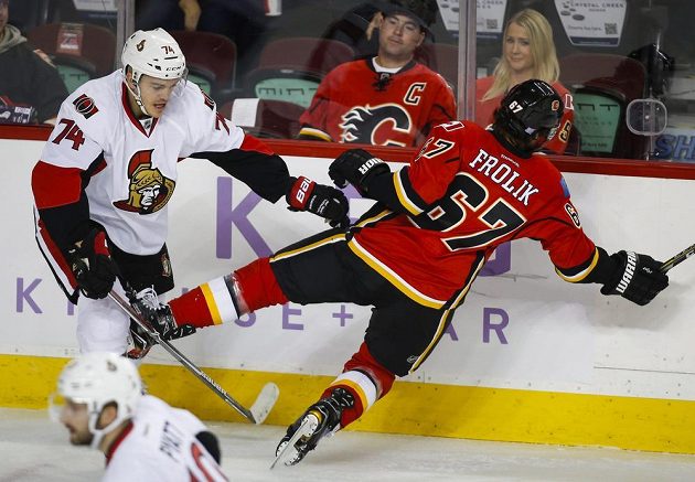 Útočník Calgary Michael Frolík inkasoval tvrdý hit od obránce Ottawy Marka Borowieckiho.