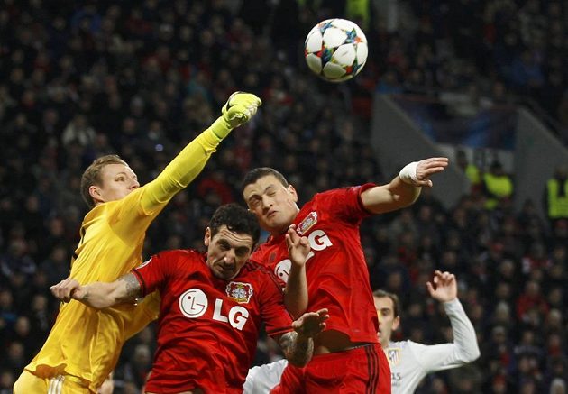 Brankář Bayeru Leverkusen Bernd Leno ve spolupráci s Robertem Hilbertem a Kyriakosem Papadopulosem (zleva) odvrací míč v osmifinále Ligy mistrů proti Atlétiku.