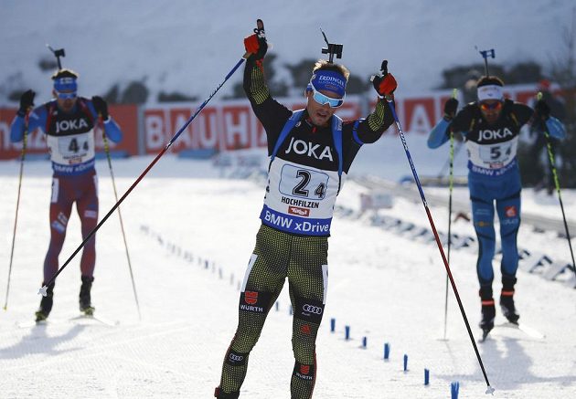 Vítězné gesto Němce Simona Schemppa v cíli závodu smíšených štafet na MS v rakouském Hochfilzenu. Za ním bojují o druhé místo Francouz Martin Fourcade z Francie (vpravo) a Rus Anton Šipulin.
